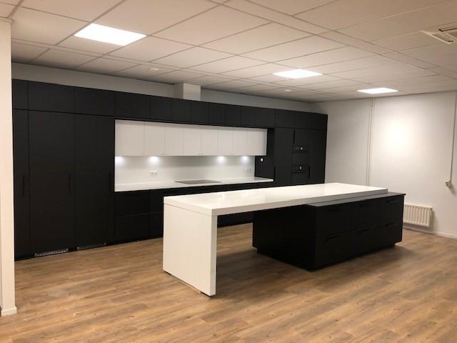 Zwart kookeiland met wit werkblad in de pantry van de kantine