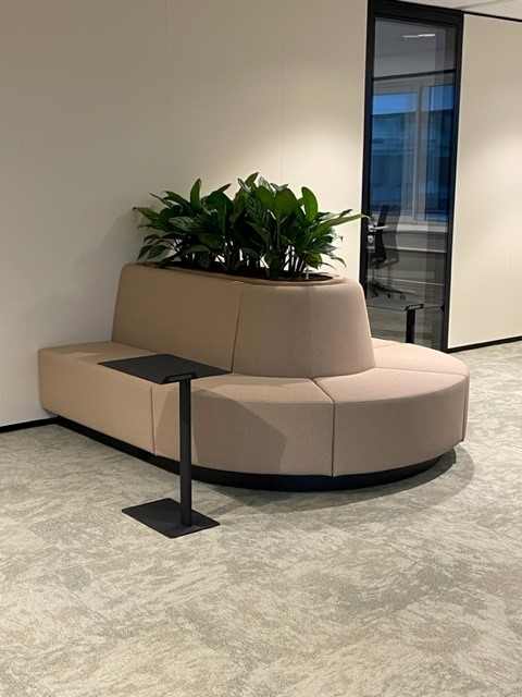 Ronde loungebank in beige met groene planten als ontmoetingsplek