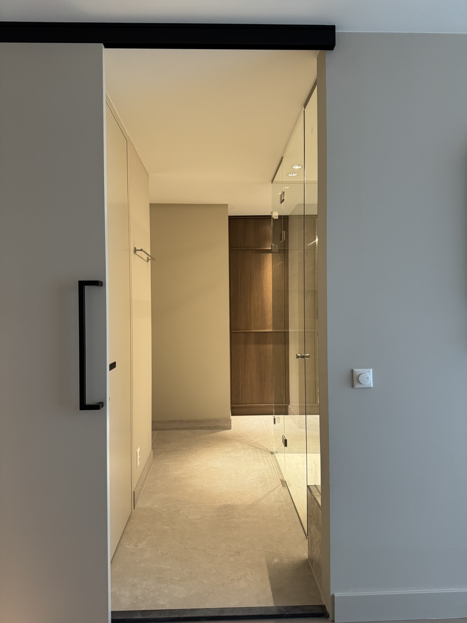 Schuifpui naar de en-suite badkamer met glazen inloopdouche