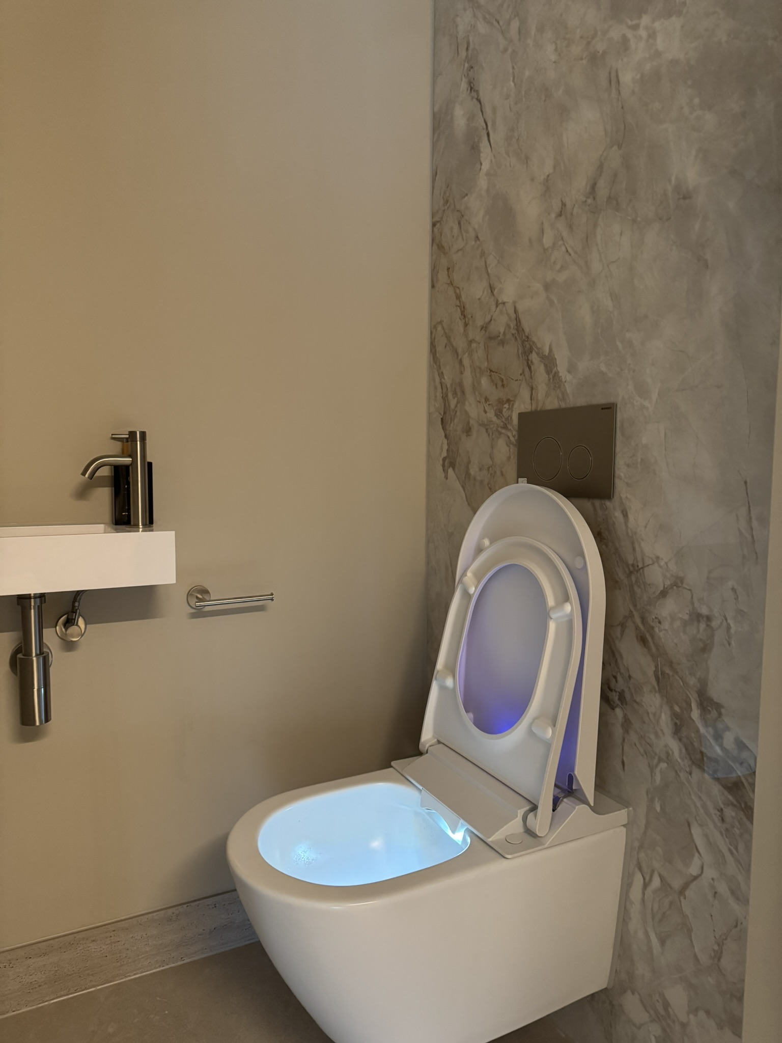 Tweede toiletruimte met wandcloset en natuurstenen wand